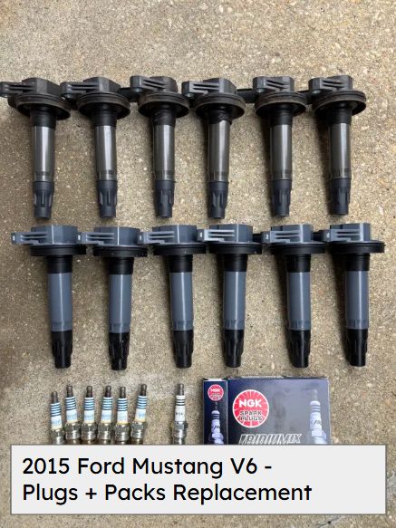 Twelve ignition coil packs and new spark plugs laid out for a tune-up on a 2015 Ford Mustang V6