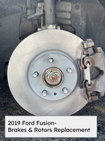 New brake rotor and caliper installed on the front hub of a 2019 Ford Fusion